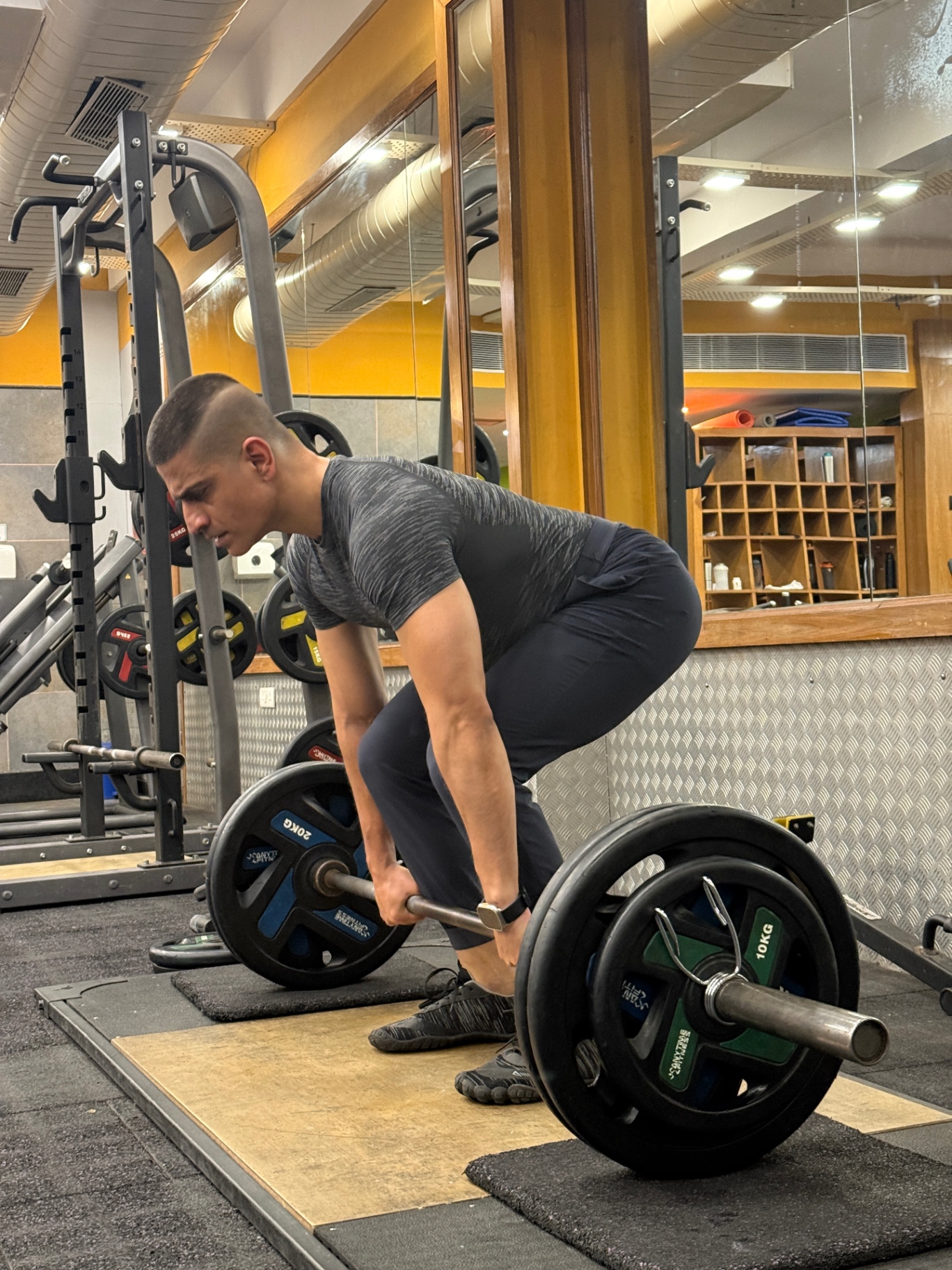 Shiva Malhotra ACE certified personal trainer performing a heavy barbell deadlift in minimalist shoes, demonstrating progressive strength training for adults over 35