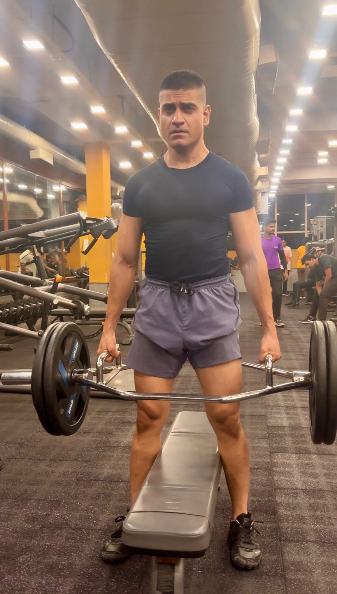 Shiva Malhotra ACE certified personal trainer standing over a loaded trap bar in the gym, demonstrating weight training for adults over 35