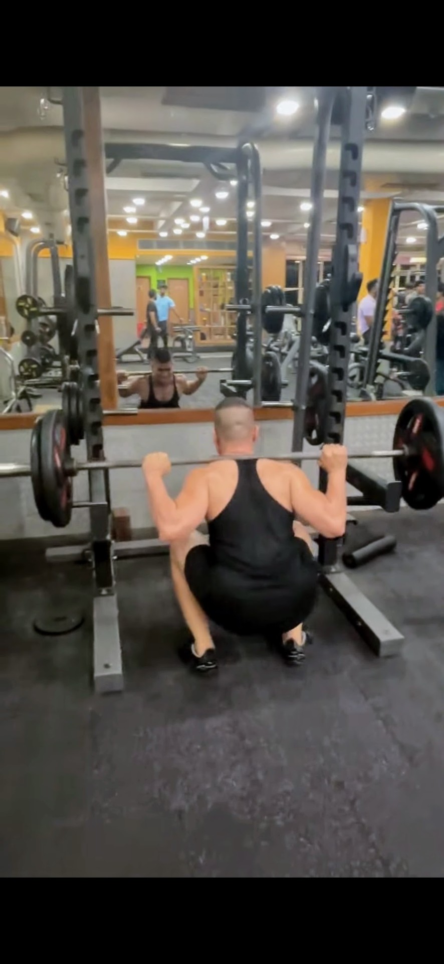 Shiva Malhotra performing a barbell back squat — deep squat coaching for adults over 35
