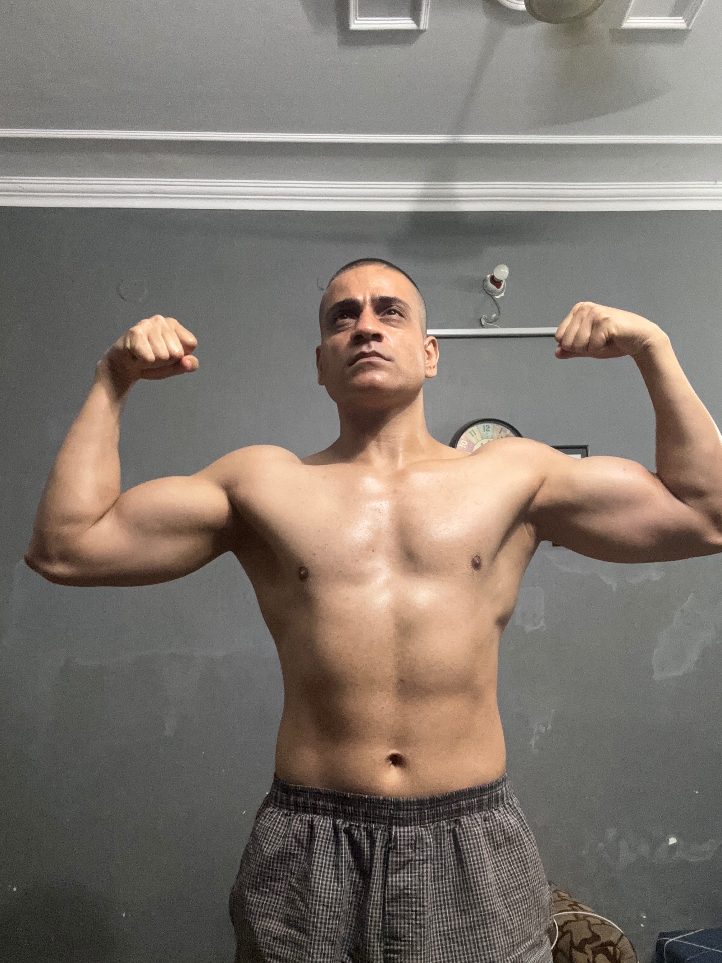 Shiva Malhotra flexing biceps in a double-biceps pose, showing significant muscle mass