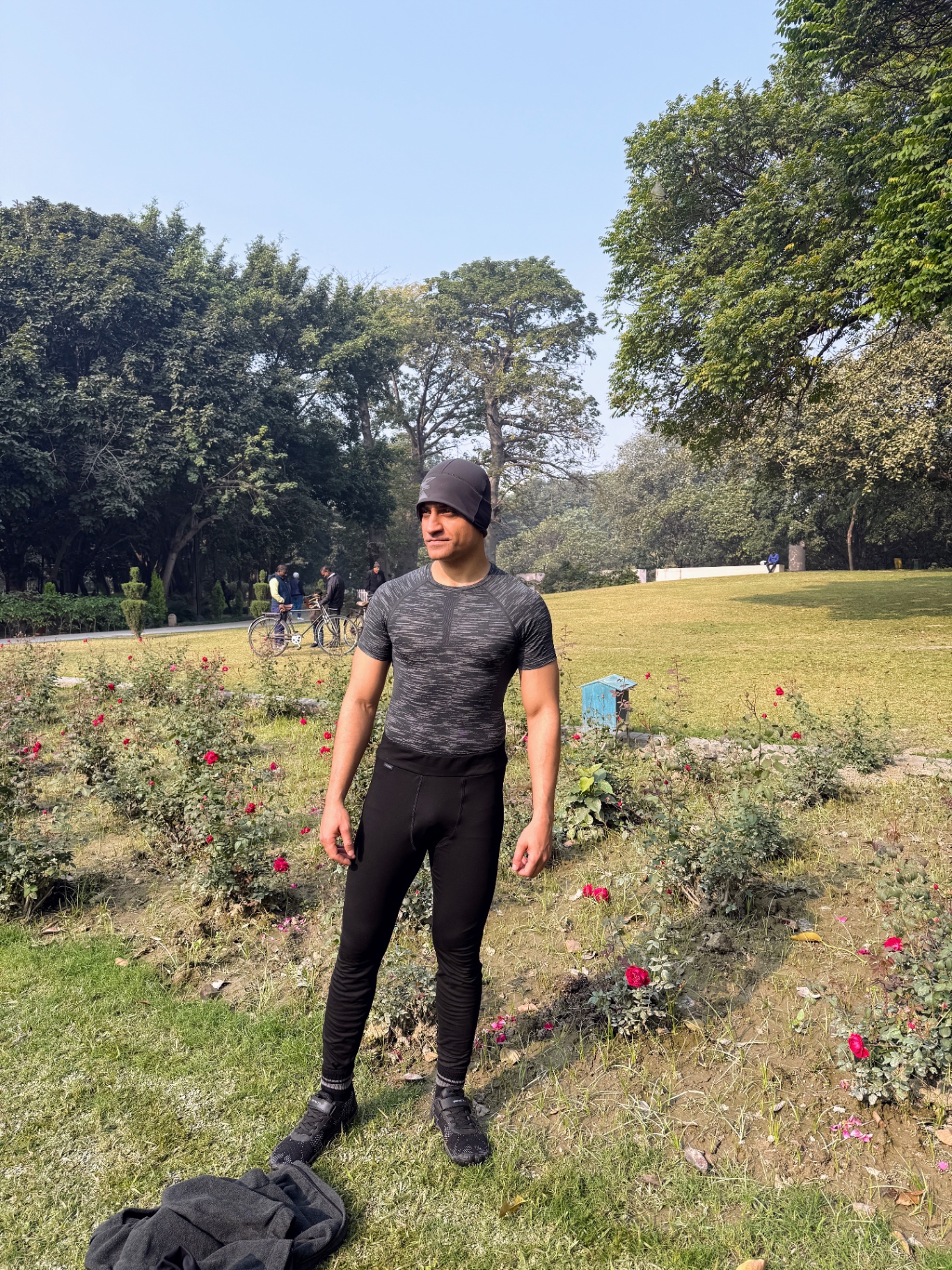 Shiva Malhotra ACE certified personal trainer standing outdoors in a park in workout gear — an outdoor walk during a fast supports the body's natural fasted state